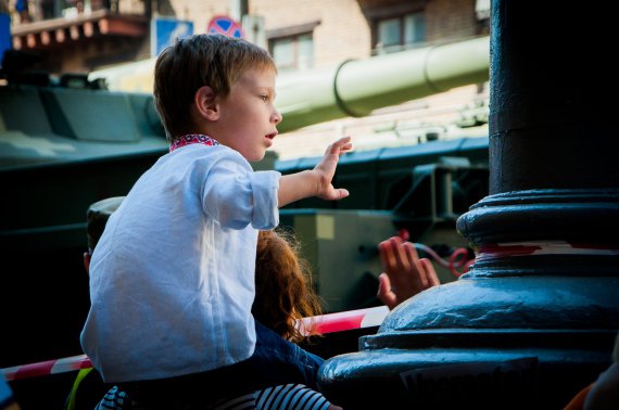 Дети приветствуют проезжающую мимо военную технику