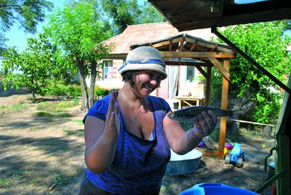 Жителька села Покровка на Кінбурнській косі показує туристам рибу, що водиться в цих місцях