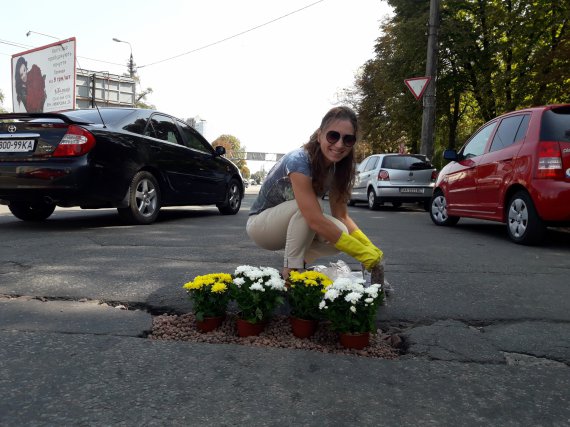 Яму залатали цветами на разветвлении столичной ул. Семена Скляренко и просп. Степана Бандеры возле салона по продаже электромобилей ElectroCars