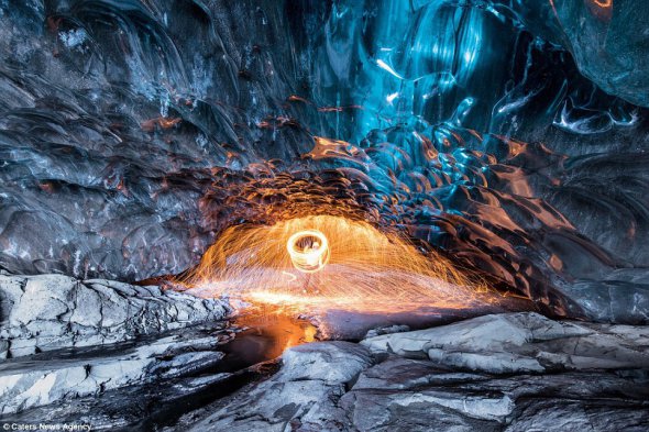 Экскурсовод показывает фаершоу в исландском леднике Ватнайкуль