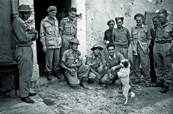 Грецькі солдати спостерігають за дресированим собакою в італійському місті Ріміні, 21 вересня 1944 року. Тварина була талісманом 3-ї грецької гірської бригади. Частина брала участь у звільненні Італії від фашистів