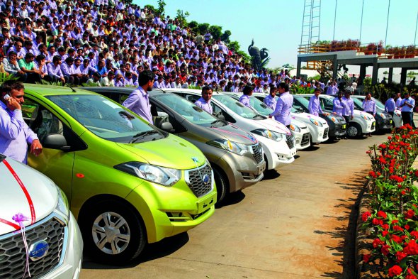 Працівники індійської компанії Hari Krishna Exports фотографуються біля подарованих автомобілів у Нью-Делі. Цього року власник обіцяє надати 100 квартир, 300 машин і 500 наборів прикрас найкращим співробітникам