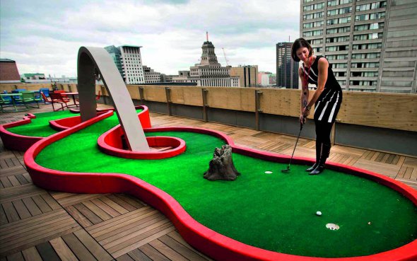 Працівниця компанії Google Андреа Янус грає в гольф у зоні для відпочинку. Вона розташована на балконі будівлі в канадському Торонто