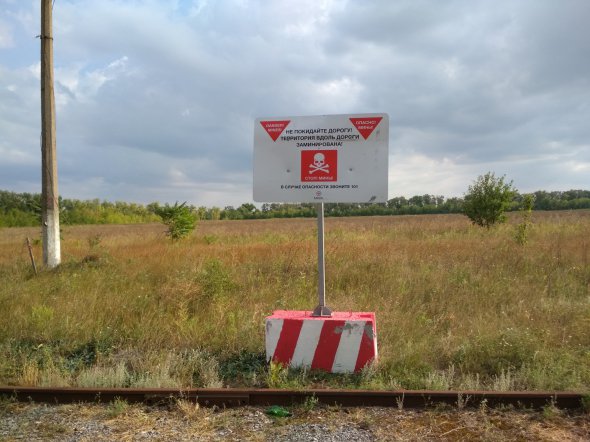 Табличка о том, что выходить за пределы железнодорожного пути запрещено - территория заминирована