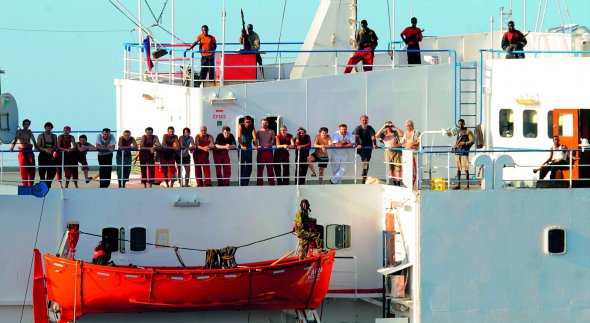 За судном ”Фаїна”, яке захопили сомалійські пірати, спостерігали моряки американського есмінця. Вони сфотографували членів екіпажу з озброєними нападниками на палубі