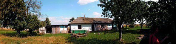Сарай стоїть навпроти хати Ольги Мороз на хуторі Мартинівка Тернопільської області. Жінка тримає птицю. Кілька років тому в неї вкрали дві корови