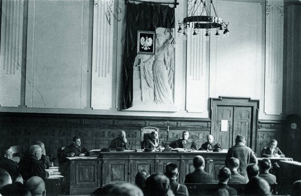 Голова самбірського суду доктор Станіслав Вондравш (по центру) разом з іншими суддями слухають свідка у справі вбивства депутата сейму Тадеуша Голуфка, жовтень 1933 року