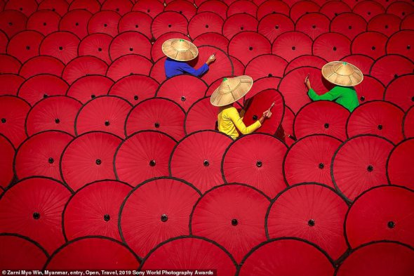 Працівниці фарбують традиційні парасольки у М'янмі, Африка. "Метою цього цього знімку було зобразити контраст червоного, зеленого, синього і жовтого кольорів. Коли я побачив ці красиві парасольки, мене надихнули кольори і візерунки. Я знімав цю сцену чотири рази. Витратив чотири місяці, щоб спіймати саме цей момент", - розповів фотограф Зарні Міо Він 