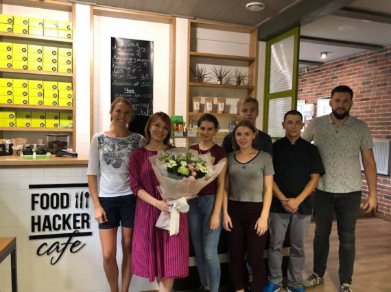 На фото головний дієтолог кафе FoodHacker Олена Семеніхіна (на фото з букетом) з Геннадієм Харламбовим (крайній праворуч) та працівниками закладу