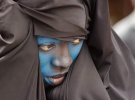 Жінка з обличчям, покрашеним в синій, на параді Циннері в Брюсселі, Бельгія