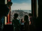 Сім’я стоїть на фоні Манхеттена на 80-тому поверсі хмарочоса Емпайр-Стейт-Білдінґ