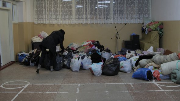 Жители Нежина Черниговской сносят гуманитарную помощь в помещение школы № 17, где принимают временных переселенцев