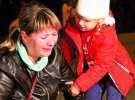 Жінка плаче біля політехнічного коледжу в анексованому кримському місті Керч. Прийшла із дитиною до встановленого меморіалу загиблим