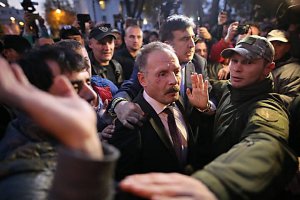 Народний депутат Олег Барна (по центру) виривається з оточення мітингувальників біля Верховної Ради 17 жовтня 2017 року. Його побили й обплювали. Під правим оком має великий синець