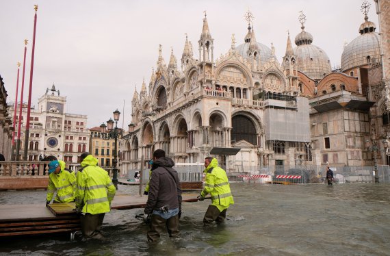 Рабочие сооружают временный переход на площади Святого Марка в Венеции