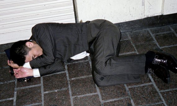Японцы спят на улице под открытым небом. Автор фото говорит, что они засыпают от усталости, или написаються, чтобы снять стресс