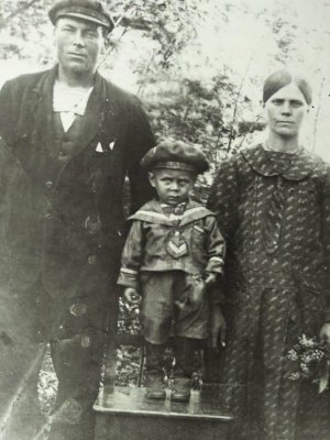 2-річний Володимир Короташ стоїть на стільчику, за ним — батько Михайло та матір Ольга, 1928 рік