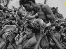 3 место в категории "Люди" получило фото "Любовь и жизнь". Индуист целует своего новорожденного ребенка во время религиозного праздника Чарак-пуджа в честь бога-разрушителя Шивы в Западной Бенгалии, Индия. Мужчины пробивают спины крючками с веревками и качаются на них. Люди считают, что, удовлетворив Шиву, наступит благополучие, а детей это убережет от тревоги. "Я пытался захватить момент любви и показать заботу отца о своем маленьком сыне", - говорит автор снимка Авишек Дас