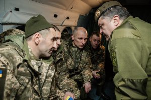 Президент Петро Порошенко на борту вертольота спілкується зі звільненими з полону бойовиків на Донбасі українськими військовослужбовцями. 27 грудня торік додому повернулися 73 українці