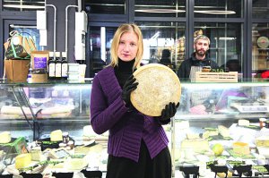 Ольга Терницька тримає головку твердого сиру. Найдорожчий у неї в магазині — з буйволячого молока. Коштує 900 гривень за кілограм