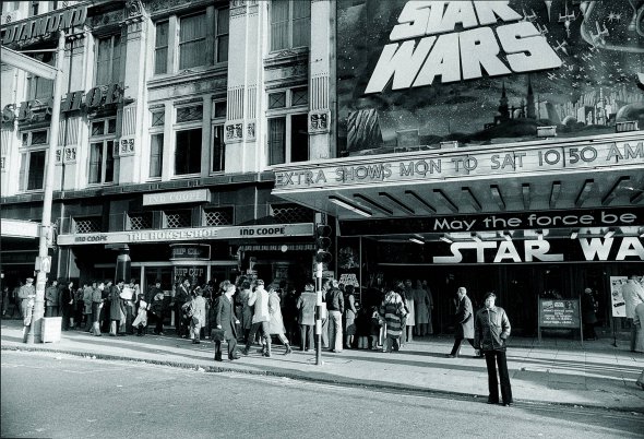 Люди стоять у черзі по квитки на фільм ”Зоряні війни” в кінотеатрі в центрі Лондона 27 грудня 1977 року. Стрічка вийшла у прокат за шість місяців до цього, але інтерес до неї не згас. Квитки по 2,2 фунта стерлінгів перепродавали по 30. Це половина тодішнього середнього тижневого заробітку англійців