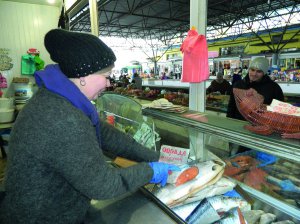 Продавець вінницького ринку Урожай Алла Грищенко відрізає шматок охолодженої норвезької сьомги. Кілограм риби продає за 535 гри­вень. Торік її ціна була 480. Найдорожча червона ікра коштує 480 гривень за 140 грамів