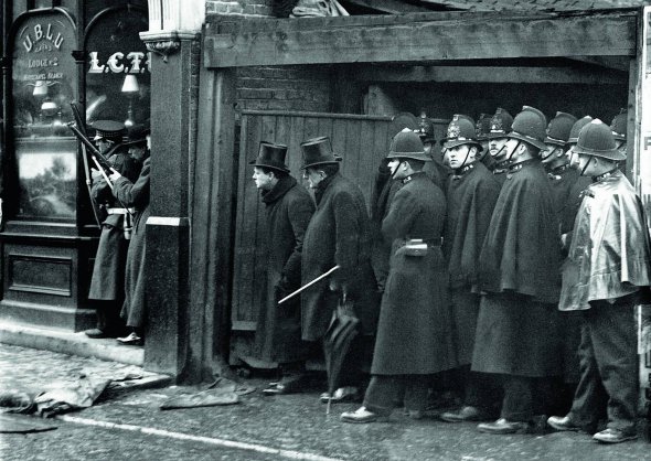 Міністр внутрішніх справ Великої Британії 36-річний Вінстон Черчилль (стоїть попереду групи поліцейських у шоломах, у нього на голові циліндр) керує операцією із затримання злочинців на Сідней-стріт у Лондоні 3 січня 1911-го. Троє представників анархістської організації ”Полум’я” хотіли пограбувати ювелірний магазин. Їх помітила поліція. Нападники забарикадувалися й почали відстрілюватися. Під час операції загинули двоє бандитів і троє поліцейських. Черчилль очолював відомство майже два роки, потім перейшов у військове міністерство