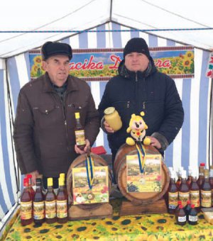 Бджолярі Петро Деркач із сином Олександром на новорічному ярмарку в Решетилівці.  Найкраще продавалась медовуха