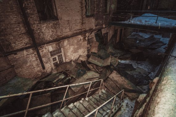 На фото обгорілої будівлі видно її обвуглені стіни, а біля входу на снігу ще лежать уламки даху.