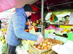 На вінницькому ринку Привокзальний продавець 29-річний Павло Степанюк зважує покупцю цибулю. Кілограм коштує 17,5 гривні