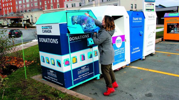 Жінка перекидає одяг у контейнер для збору допомоги хворим на діабет у Канаді. Таких встановили понад три тисячі по всій країні
