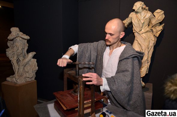 Мужчина реконструктор демонстрирует как печатали книги в древности