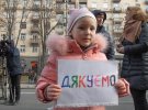 Поміж бійців бігає маленька дівчинка з плакатиком "Дякую". "Я  вдячна захисникам України",-каже вона