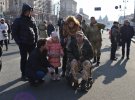 Маленька фотографується разом із ветераном, який сидить в інвалідному візочку