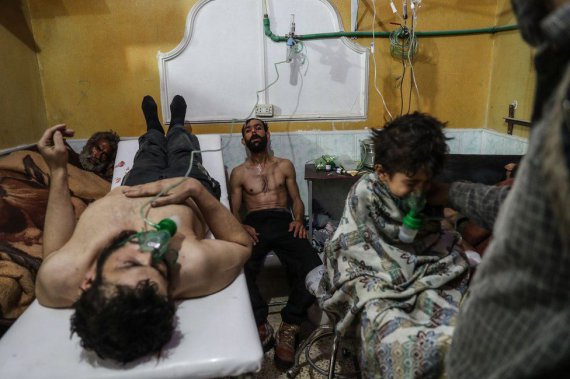 Фото называется "Жертвы возможной атаки в Восточной Гуте лечатся". Оно сделано в феврале 2018 года. Во время решающего штурма пригорода Дамаска жители Восточной Гуты подверглись массовому обстрелу и, вероятно, по меньшей мере одной газовой атаке.