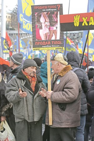 Чоловіки тримають плакат з гаслом ”Продаєш голос на виборах — продай тіло. Заробиш більше”. 24 лютого на майдані Незалежності у столиці відбулося Віче гідності за чесні вибори, організоване націоналістичними рухами