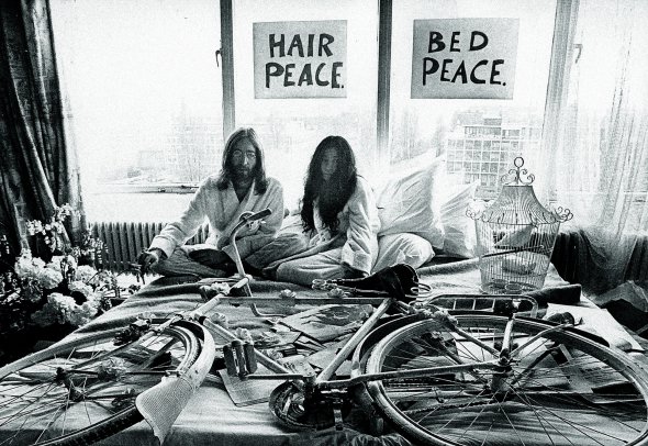 Музикант 29-річний Джон Леннон із дружиною художницею Йоко Оно, 36 років, сидять на ліжку в президентському номері готелю Hilton в Амстердамі 27 березня 1969-го. Вони щойно одружилися. Замість медового місяця влаштували перфоманс ”У ліжку за мир”. Тиждень провели в готельному номері на знак протесту проти дій армії США у В’єтнамі. У будь-який час доби до них могли зайти журналісти. Пара давала інтерв’ю і закликала до мирного розв’язання конфліктів