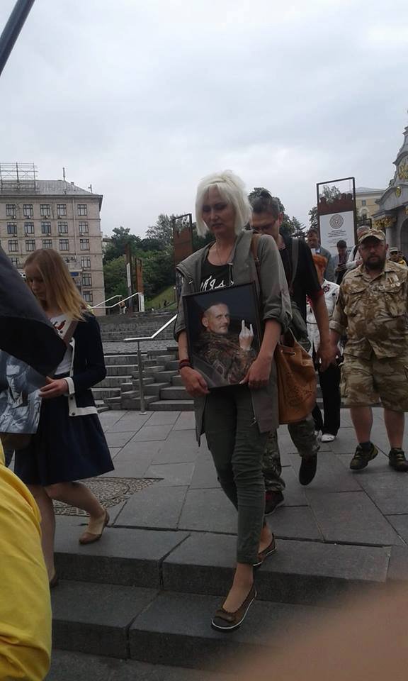 Жена Яна Сумская несет фотографию погибшего мужчины во время похорон на площади Независимости в центре Киева