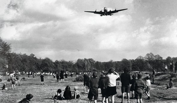 Діти із Західного Берліна чекають на американські літаки, пілоти яких скидали шоколадки й цукерки. 1948 року місто блокували радянські війська і продукти доставляли зі США