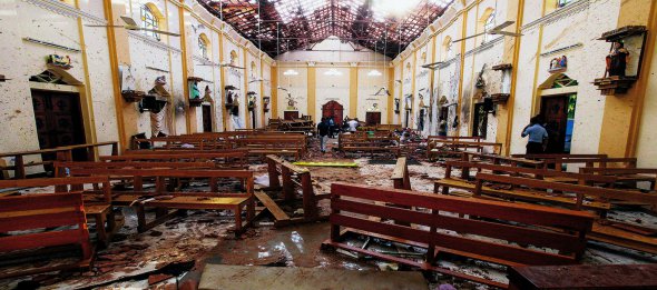 Чоловіки прибирають після теракту в католицькій церкві в місті Баттікалоа, Шрі-Ланка. Смертник підірвався у храмі під час Великодньої служби. Загинули понад 80 людей