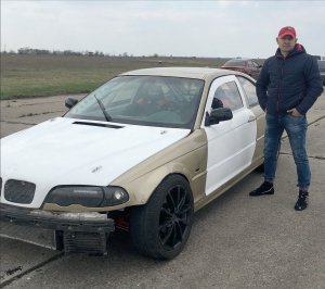 Олександр Папанов стоїть біля своєї машини БМВ. ” Автоспорт — не дешеве заняття. За день тренувань стирається дуже багато коліс”, — каже пілот