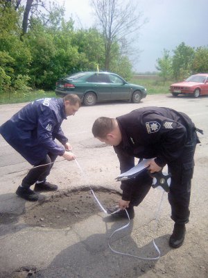 Поліцейські міряють яму на дорозі Фурси – Трушки. Перед цим тут мітингували водії. Вимагали полагодити частину дороги