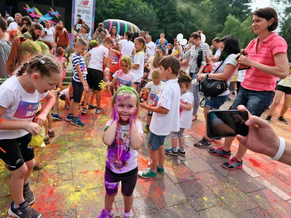 Вимащена індійськими фарбами холі дівчинка, стоїть серед учасників забігу Lviv Color Run 22 червня. Неповнолітні долали дистанцію 400 метрів. Дорослі бігли щонайбільше шість кілометрів. Учасники могли робити благодійні внески на лікування дітей. За реєстрацію платили 100 гривень