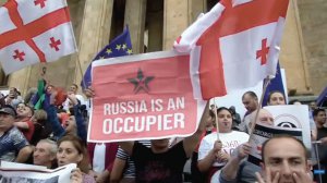 Люди тримають плакат із написом ”Росія — окупант” 3 липня в грузинській столиці Тбілісі. Протестують проти окупації двох регіонів країни — Абхазії та Південної Осетії