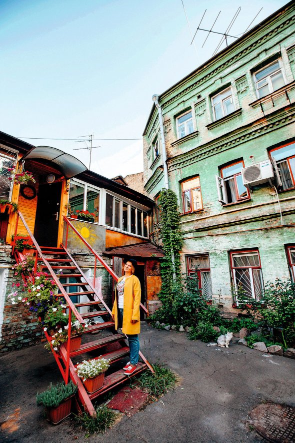Гід Софія Грабовецька стоїть на дерев’яних сходах до однієї з квартир на вулиці Хорива в Києві. Раніше тут був завод штучних мінеральних вод