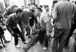 Прихильники колишнього президента Киргизстану Алмазбека Атамбаєва оточили пораненого силовика. 7 серпня 2019 року, селище Кой-Таш поблизу Бішкека, Киргизстан