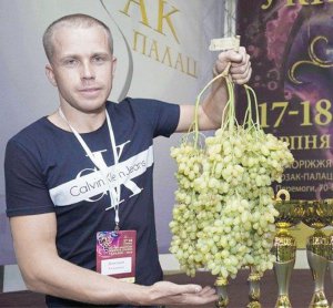 Дмитро Ткаченко з міста Покров Дніпропетровської області показує гроно винограду, яке виростив у своєму саду. Наступного року планує побити власний рекорд