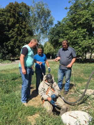 Працівники водоканалу розчищають забиту стічну трубу на вулиці Грушевського