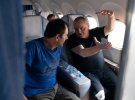 Володимир Балух (у синьому) спілкується з звільненим у літаку