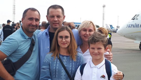 Журналіст Роман Сущенко (посередині) поруч зі своєю сім'єю в аеропорту "Бориспіль" під час обміну. Фото: Укрінформ